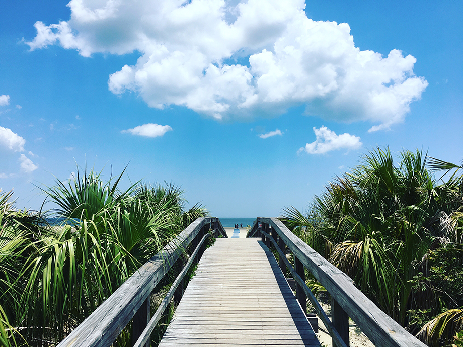 Boardwalk leading to beach on bright sunny day