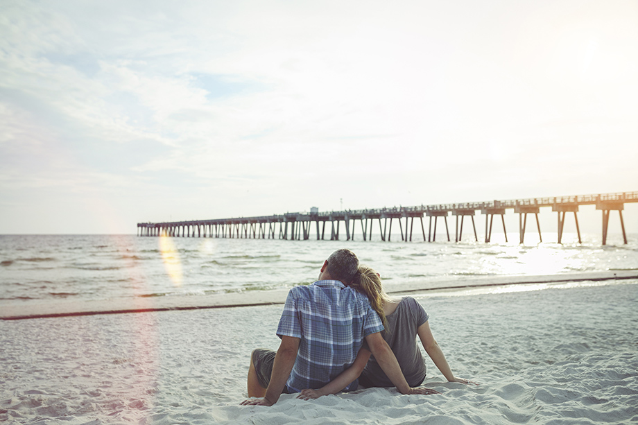 Couple sitting on beach looking at ocean